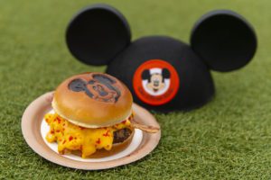 Mickey Cheeseburger – Angus burger with macaroni and cheese, American cheese, cheese sauce, and spicy cheese dust on a Mickey Mouse Bun; available at Cosmic Ray’s Starlight Cafe
