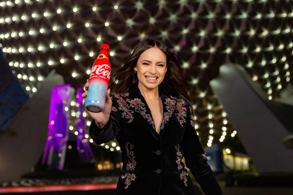 To celebrate the 50-year collaboration between Walt Disney World Resort and Coca-Cola, Sofia Carson helped unveil five unique co-branded collectible bottles that are now available exclusively at the resort during the 50th Anniversary Celebration. Sold at locations throughout each of the four Walt Disney World theme parks, there are four different bottles featuring each of the 4 park icons with their own unique EARisdescent color on the labels, plus a fifth bottle with a special gold label. The bottles are shaped just like the bottles that were sold at Walt Disney World when it opened in 1971