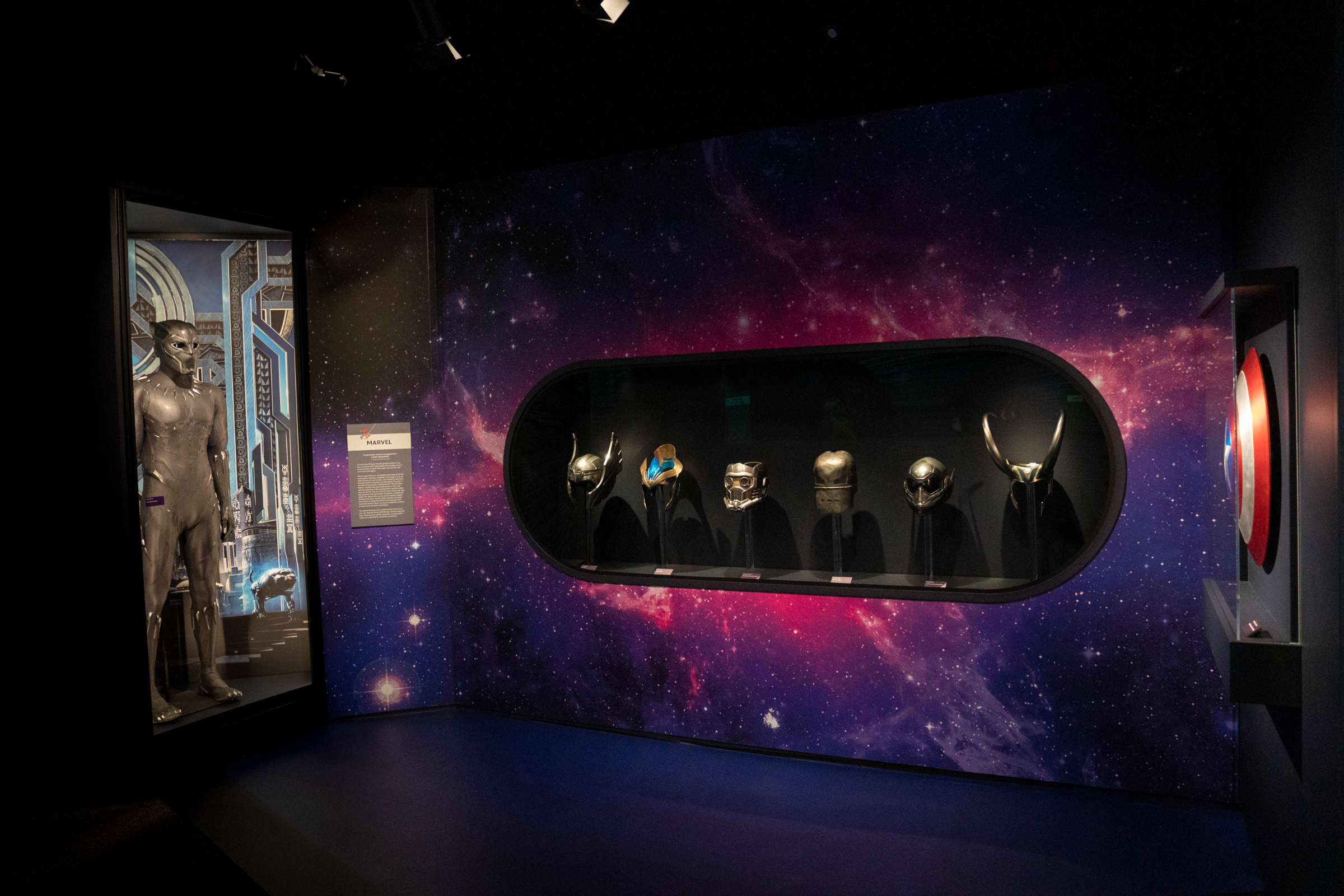 Black Panther costume (Black Panther, 2018), Marvel Studios character helmets and masks, and Captain America shield (Captain America: Civil War, 2016) featured inside The Spirit of Adventure and Discovery gallery at Disney100: The Exhibition, now open at The Franklin Institute in Philadelphia. ©MARVEL