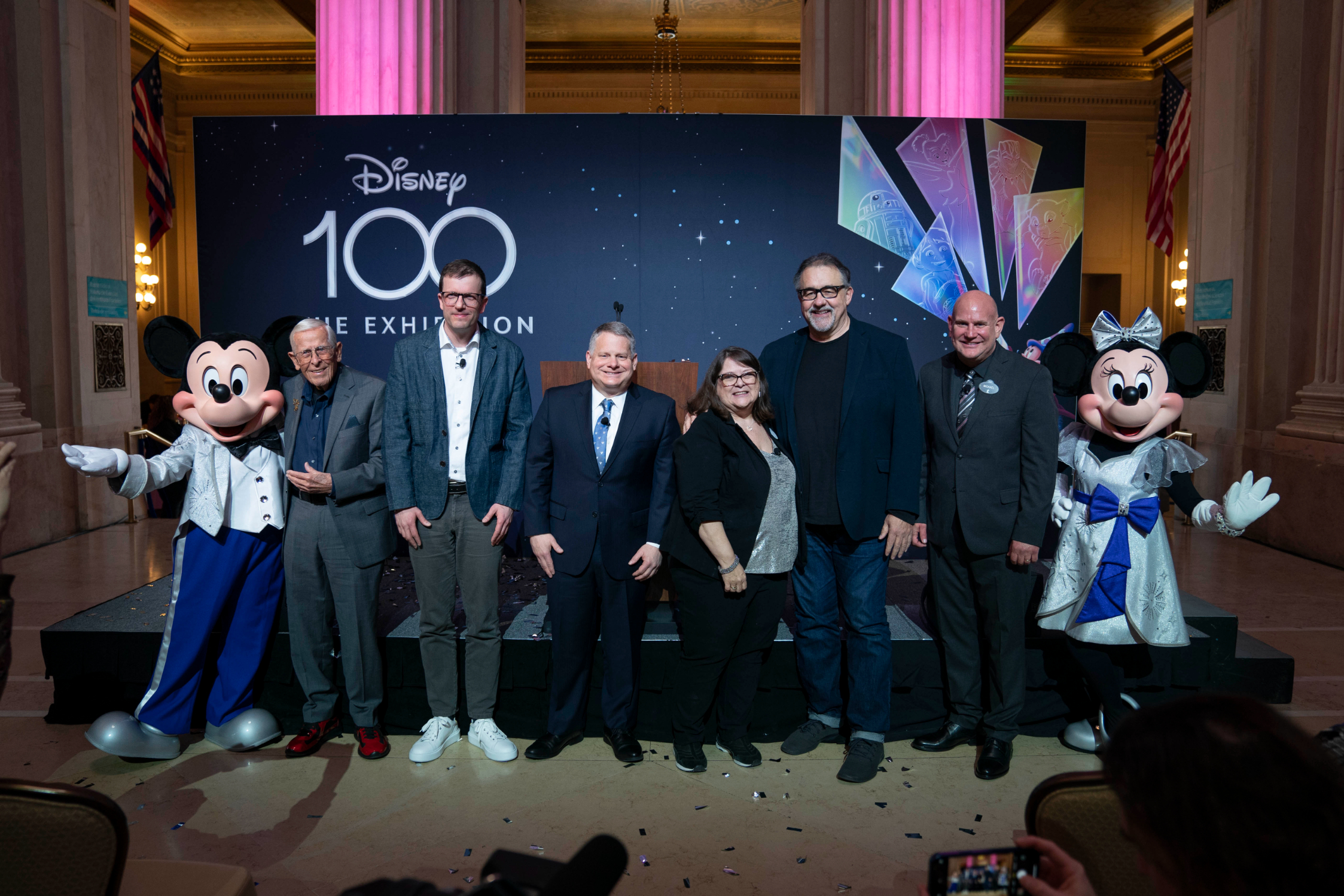 Mickey and Minnie at the DIsney 100 Exhibition (L to R): Mickey Mouse, Disney Legend Bob Gurr, Semmel Exhibitions Executive Producer and Director Christoph Scholz, The Franklin Institute President and CEO Larry Dubinski, Walt Disney Archives Director Becky Cline, Disney Legend Don Hahn, Walt Disney Archives and D23: The Official Disney Fan Club Vice President Michael Vargo, Minnie Mouse