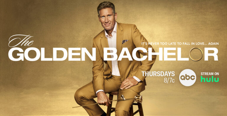 Gerry Turner, ABC’s first Golden Bachelor, sitting on a brown stool while holding a gold rose. “The Golden Bachelor” premieres Thursday Sept 28 on ABC. Stream on Hulu.