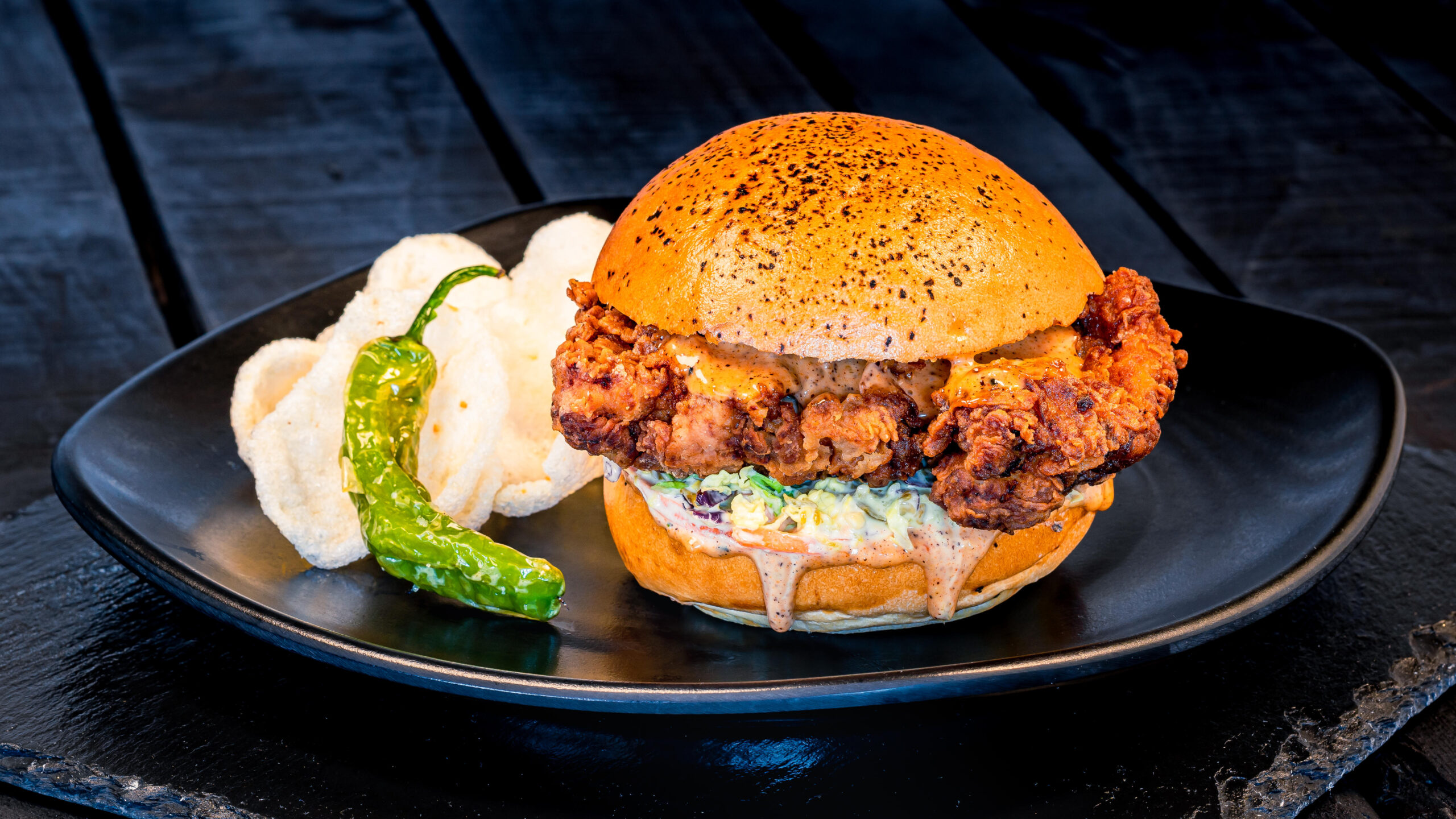 Karaage-inspired Crispy Chicken Sandwich (Lucky Fortune Cookery) – with slaw, and Togarashi mayonnaise on a potato bun served with garlic chips. Available beginning July 19, 2023. For more details, visit DisneyParksBlog.com. (David Nguyen/Disneyland Resort)