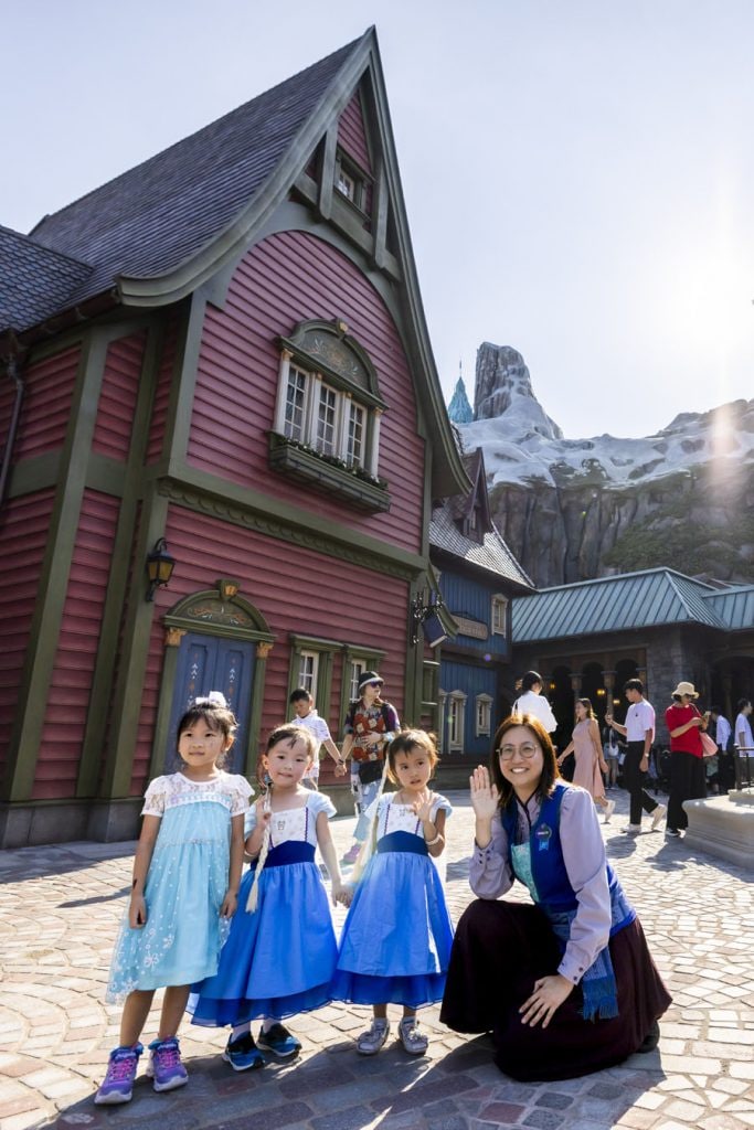 A citizen of Arendelle with three young guests wearing Frozen-themed costumes