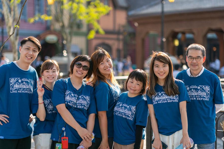 A family posing together in Arendelle wearing matching World of Frozen shirts