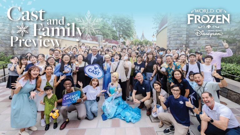 A group of cast members posing at the entrance to World of Frozen in Hong Kong Disneyland