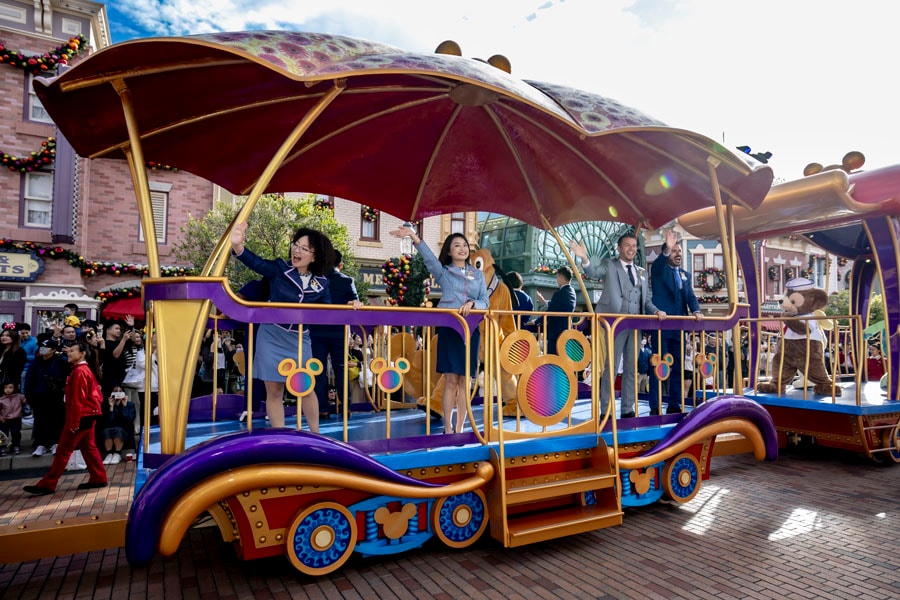 Disney Ambassadors wave at guests while riding aboard a parade float down Main Street, U.S.A. at Hong Kong Disneyland
