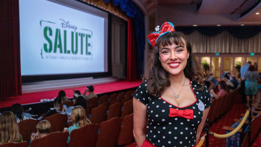 Person stands next to Disney Salute sign in red, white and blue