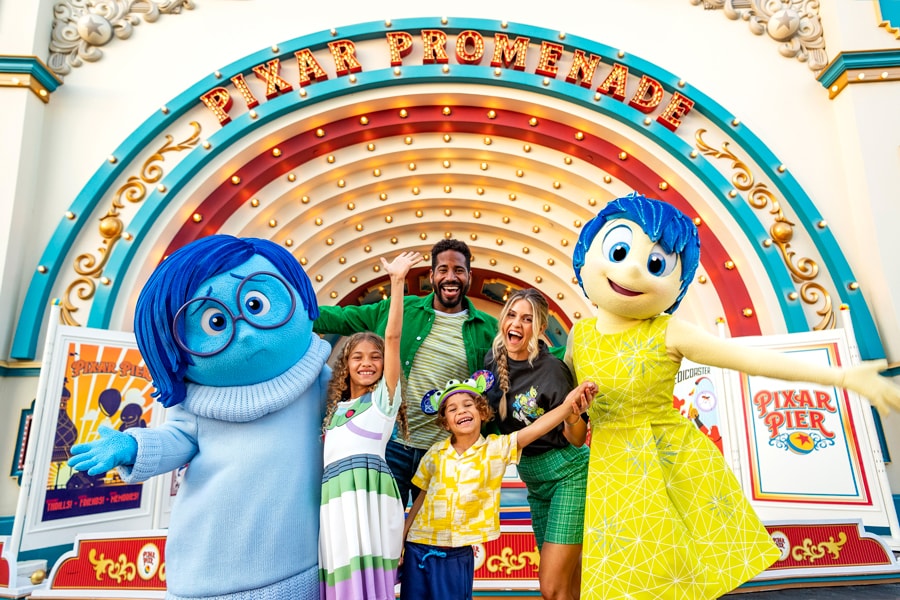Sadness and Joy from "Inside Out" with a family at Disney California Adventure park