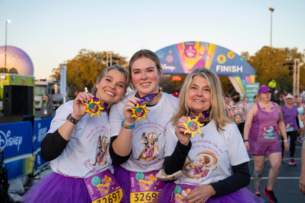 Kim Schaefer (right), 67, shows off her medal after finishing the Disney Princess 10K presented by CORKCICLE with her daughter and granddaughter. The runDisney event was the first race for Schaefer who underwent double lung transplant surgery in 2020 after she was diagnosed with interstitial lung disease. The family from Colorado completed the race at Walt Disney World Resort in Lake Buena Vista, Fla. on Saturday, Feb. 24. (Omark Reyes, photographer)