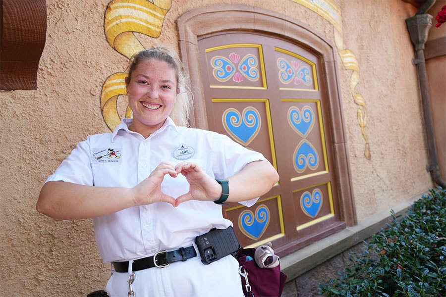 Cast member in front of blue hearts in the Germany Pavilion in EPCOT