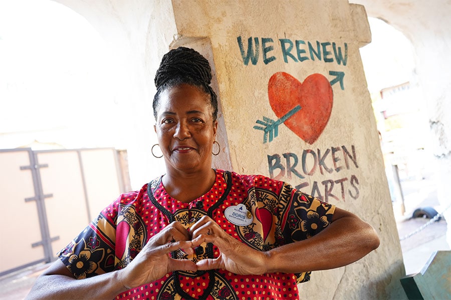Cast member in front of the “We Renew Broken Hearts” message at Disney's Animal Kingdom