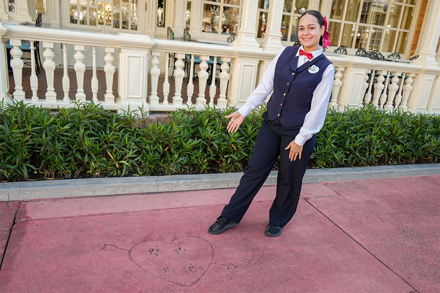 Cast member next to the Lady and the Tramp paw prints outside Tony’s Town Square Restaurant at Magic Kingdom