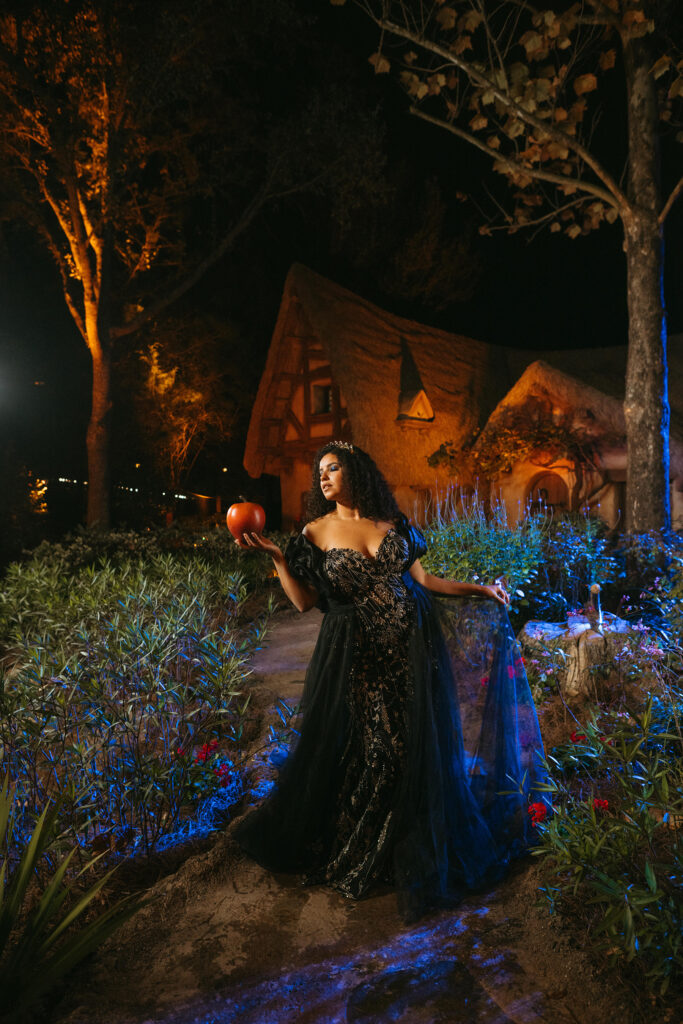 The new Disney’s evil Queen wedding gown is shown near Seven Dwarves Mine Train attraction in Magic Kingdom Park at Walt Disney World Resort in Lake Buena Vista, Fla. It is one of four new gowns inspired by Disney Villains and introduced as part of the 2024 Disney’s Fairy Tale Weddings collection from Allure Bridals. Inspired by the villain from Disney’s “Snow White and the Seven Dwarves,” the gown is adorned with linear lace, 3D floral embellishments, beads and sequins delicately scattered over tulle. The silhouette features a sweetheart neckline leading into a peaked bodice complemented by eye-catching embroidery. The gown is available in ivory, black or gold with a wrapped ruffle shawl for added elegance. (Claire Celeste, Photographer)
