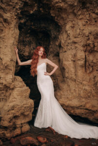 They say "Love Changes Everything," and we guarantee you'll fall head over fins for the strapless sheath silhouette featured on this Disney's Ariel-inspired bridal look, replete with beaded lace and a delicate tulle and chiffon train.