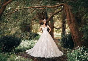 Embodying the sweetness and gentle grace of Disney's Snow White herself, this Princess-inspired ballgown draws its design inspiration from the forest surrounding the princess. Countless blooms cover the off-shoulder cap sleeves and sweetheart bodice of the gown, pooling beautifully at the hemline and giving the illusion of a fallen storm of apple blossoms.