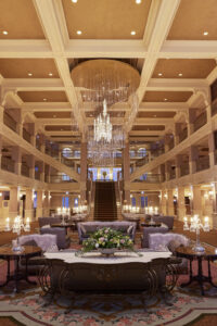 The red-carpet treatment awaits one and all at Disneyland Hotel. The royal experience begins the moment guests enter the grand lobby: an architectural masterpiece inspired by the libraries of world-famous French castles, blending prestigious materials in a symphony of ivory and gold tones