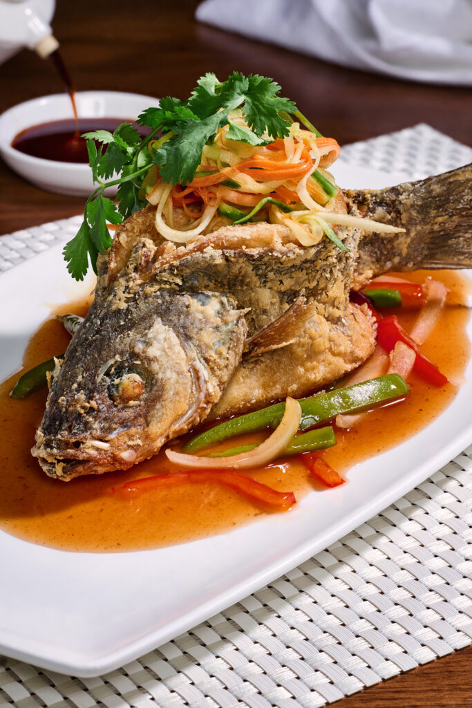 •Flash Fried Whole Branzino, served with sweet and sour sauce and cucumber slaw as well as a choice of white or brown rice. An arrangement of Chinese cuisine,  and Chef Masaharu Morimoto signature dish