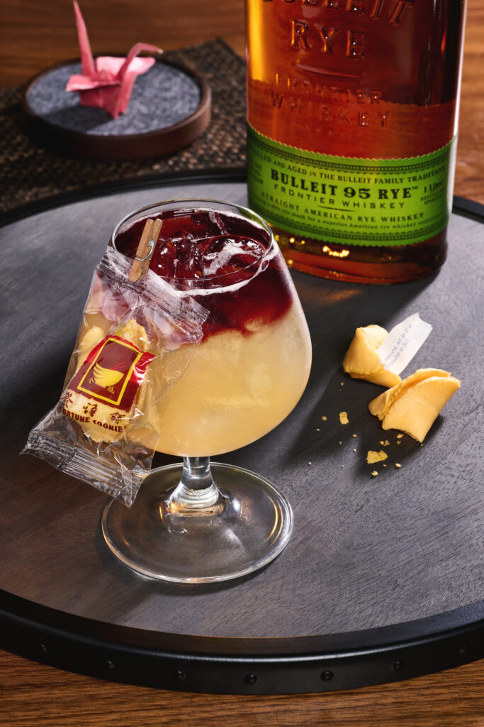 Good Fortune: Bulleit rye whiskey, apple brandy, peach liqueur, agave, lemon and ginger bitters, topped with red wine. Garnished with a fortune cookie clip on the side
