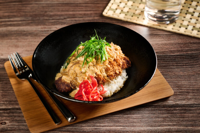 Katsudon: Indulge in a delightful combination of Panko breaded pork skirt, dashi soy, organic egg, scallions, and pickled ginger, served atop house-polished white rice. ($21)