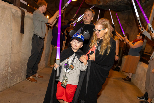 A child wields his light saber