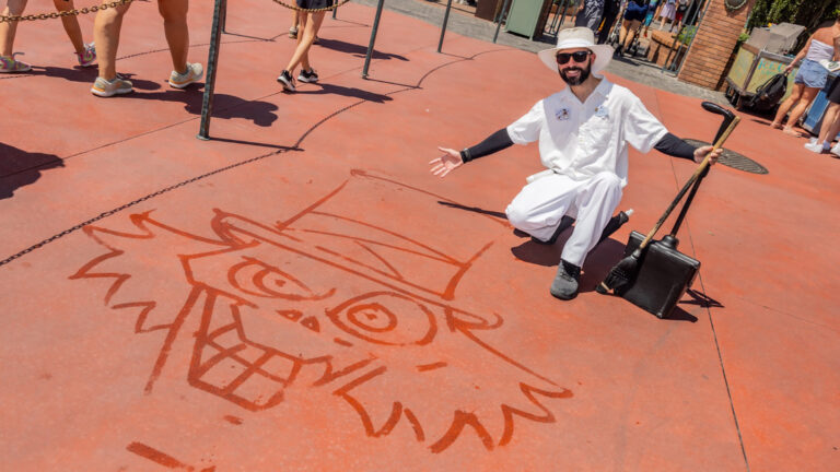 Joel poses in front of the Haunted Mansion with his completed Hatbox Ghost water art