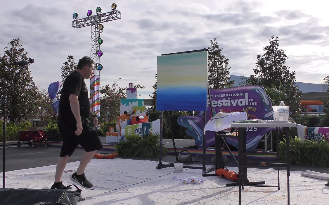 Trevor Carlton brings the whimsical Cheshire Cat to life during his live painting performance at the 2025 EPCOT Festival of the Arts in CommuniCore Plaza.