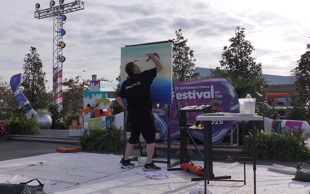 Trevor Carlton brings the whimsical Cheshire Cat to life during his live painting performance at the 2025 EPCOT Festival of the Arts in CommuniCore Plaza.
