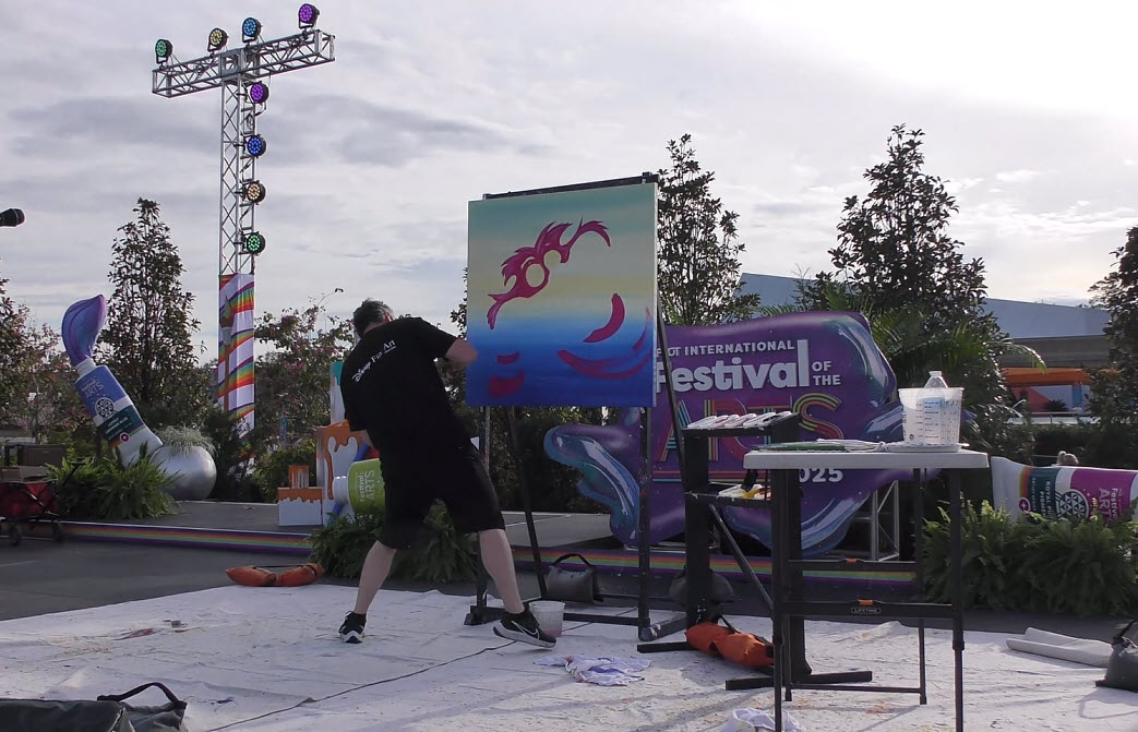 Trevor Carlton brings the whimsical Cheshire Cat to life during his live painting performance at the 2025 EPCOT Festival of the Arts in CommuniCore Plaza.