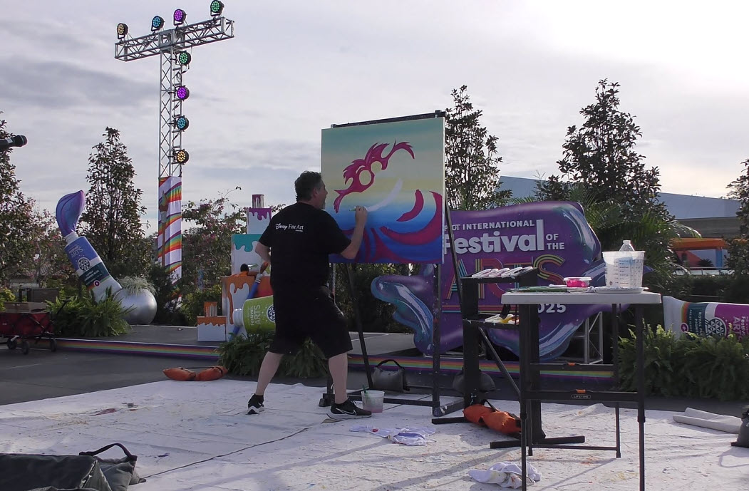 Trevor Carlton brings the whimsical Cheshire Cat to life during his live painting performance at the 2025 EPCOT Festival of the Arts in CommuniCore Plaza.