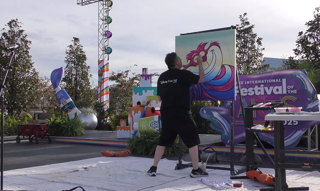 Trevor Carlton brings the whimsical Cheshire Cat to life during his live painting performance at the 2025 EPCOT Festival of the Arts in CommuniCore Plaza.