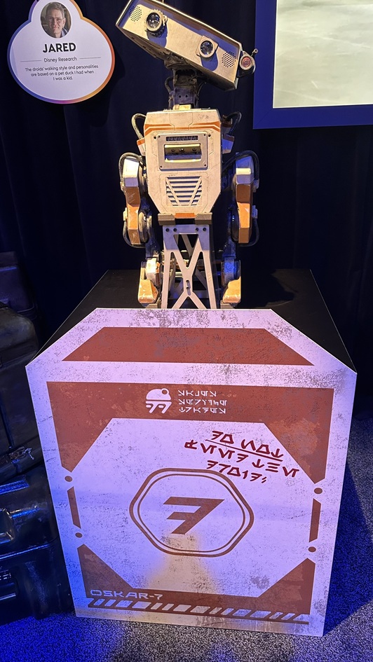 OSKAR-7, the energetic orange BDX droid, shows off its playful personality at Star Wars: Galaxy’s Edge. Always ready to engage guests with charm and quirky movement, OSKAR-7 adds a lively spark to the droid crew.